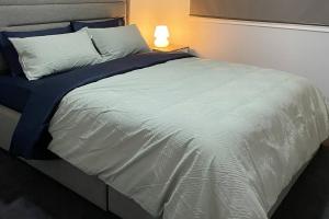 duże białe łóżko z niebieskim kocem i lampą w obiekcie Family Home in Riverdale Village Town Tarneit w mieście Tarneit