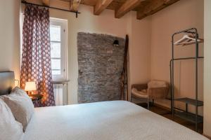 a bedroom with a bed and a stone wall at Residence V in Ponte di Legno +4 photos