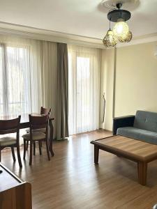 a living room with a couch and a table and chairs at Comfortable apartment with a balcony 9 in Yalova