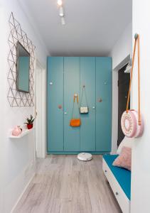 une chambre dotée d'une armoire bleue avec un porte-monnaie orange dans l'établissement Studio Alegre, à Bucarest