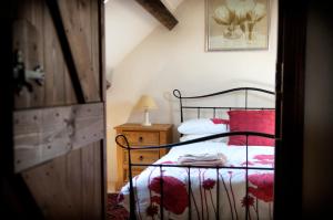 um quarto com uma cama com almofadas vermelhas em RB Contractor Stays - Helyg em Pwllheli