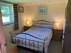 a bedroom with a bed and two lamps on night stands at RB Contractor Stays - Helyg in Pwllheli