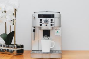 a coffee machine sitting on a table with a cup at Spacious Apartment Aleja Rzeczypospolitej with Balcony by Noclegi Renters in Gdańsk +14 photos