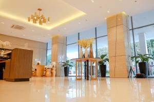 a lobby with tall windows and a table with flowers on it at Mactan Newtown Rental by EJB in Punta Engaño +38 photos