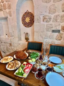 una mesa con platos de comida. en Hakkı Bey Konağı, en Savur