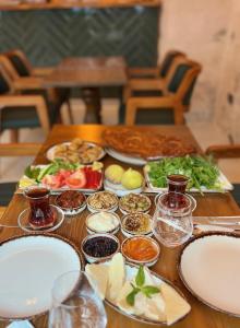 una mesa de madera con platos de comida. en Hakkı Bey Konağı, en Savur
