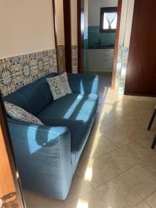 um sofá azul sentado numa sala de estar em Baglio Cracchiolo da Tuzzo - Casa Fico D'India em San Vito lo Capo