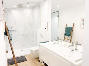 a white bathroom with a toilet and a shower at Casa Eden in Ferragudo +17 photos
