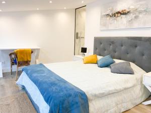 a bedroom with a large bed with blue and yellow pillows at Casa Eden in Ferragudo