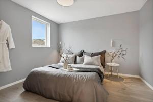 a white bedroom with a bed and a window at Cabin in Austevoll in Austevoll