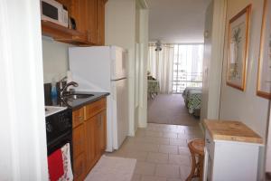 a kitchen with a sink and a refrigerator at Waikiki Studio at Ilikai Marina - great apartment by the beach - see low end price! in Honolulu