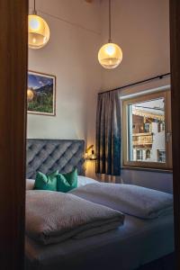 a bedroom with a bed with green pillows and a window at Apart. Oberhof in Gerlos
