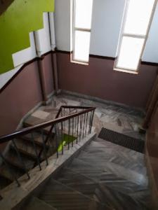 an empty room with a staircase and two windows at Hotel santi vihar,Jehanabad in Jahānābād
