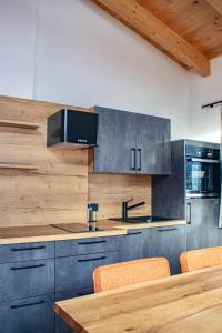 a kitchen with blue cabinets and a wooden table at Apart. Oberhof in Gerlos