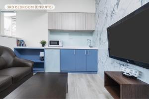 a kitchen with blue cabinets and a tv in a living room at Modern Taipei Main Station Home 3B3b 台北車站現代之家 3房3衛 in Taipei