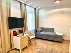 un soggiorno con divano e TV di MIRABELLE Homes a Salisburgo