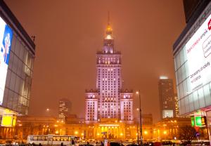 a large building with a tower in a city at night at Central Station Hostel in Warsaw