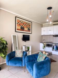 ダーバンにあるPoint water front executive apartmentのリビングルーム(青いソファ2台付)、キッチン