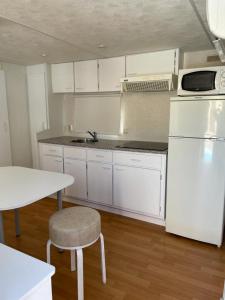 a kitchen with white cabinets and a white refrigerator at Las Tres A in Segura de la Sierra