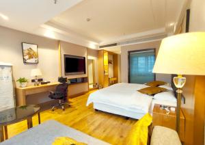 a hotel room with a large bed and a desk at Zhangjiajie ViVi Boutique Hotel in Zhangjiajie