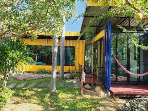 ein gelbes Haus mit einer roten Bank davor in der Unterkunft Beach Box at Pran in Sam Roi Yot