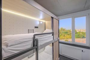Easy One Premium Art Hostel في كراكوف: سرير بطابقين في غرفة مع نافذة