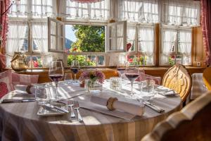 einen Tisch mit einem weißen Tischtuch und Weingläsern in der Unterkunft Hotel-Gasthaus Goldener Engel in Glottertal