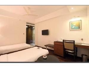 a bedroom with a bed and a desk and a table at Hotel City Inn, Kakinada, Andhra Pradesh in Kākināda