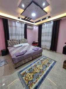 a bedroom with a bed and a rug on the floor at Petra View Flat in Wadi Musa