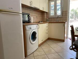 een keuken met een wasmachine en een magnetron bij Διαμέρισμα στο κέντρο της πόλης in Chios