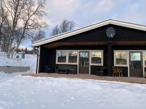 a black house with snow in front of it at 5 beds Cabin in Tänndalen, Funäsdalen in Tänndalen