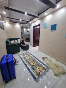 a living room with a couch and a blue suitcase at Petra View Flat in Wadi Musa