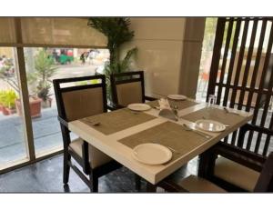 un tavolo in legno con piatti sopra di Hotel City Inn, Kakinada, Andhra Pradesh a Kākināda