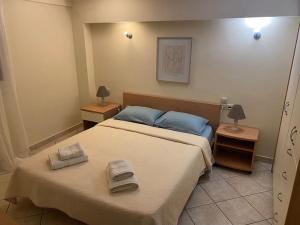 1 dormitorio con 1 cama con 2 toallas en Διαμέρισμα στο κέντρο της πόλης en Chios