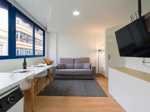 sala de estar con sofá, mesa y TV en Suites Garden Apartamento 14, en Las Palmas de Gran Canaria
