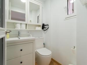 Un baño blanco con inodoro y lavabo. en Suites Garden DALI 14, en Las Palmas de Gran Canaria 3 fotos más