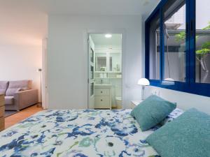 1 dormitorio con 1 cama con edredón azul y blanco en Suites Garden Apartamento 14, en Las Palmas de Gran Canaria