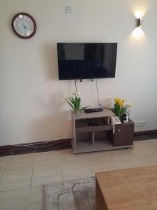 a living room with a flat screen tv on a wall at Ocean one apartment in Mombasa