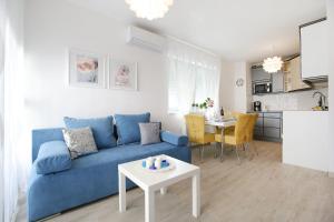 uma sala de estar com um sofá azul e uma mesa em Apartment Flowers em Zadar