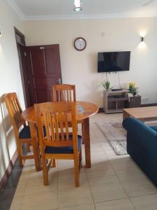 - un salon avec une table, des chaises et une télévision dans l'établissement Ocean one apartment, à Mombasa