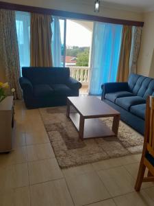 a living room with two blue couches and a coffee table at Ocean one apartment in Mombasa