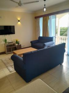 a living room with a blue couch and a table at Ocean one apartment in Mombasa