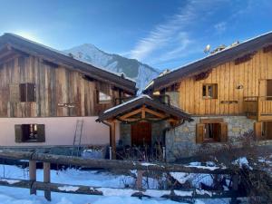 a large wooden house with snow on the roof at Chalet 6 chambres à 3 min des pistes des 3 Vallées st martin de Belleville in Béranger