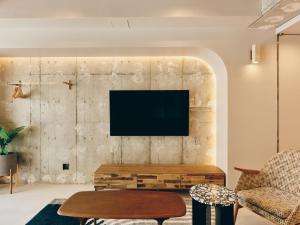 a living room with a tv on a brick wall at illi Com Shimokitazawa in Tokyo