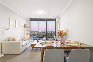 ein Wohnzimmer mit einem Tisch und einem Sofa in der Unterkunft Parramatta lovely 2br near station with City view in Sydney