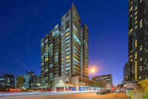 a tall building in a city at night at Parramatta lovely 2br near station with City view in Sydney