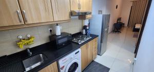 a kitchen with a refrigerator and a sink and a dishwasher at Elite 6 Sports Residence by Golden Casa in Dubai