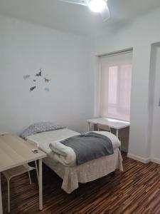 1 dormitorio con cama, escritorio y ventana en APARTAMENTO VALERIA, en Murcia