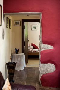 Habitación con pared roja, mesa y cama en RB Contractor Stays - Onnen, en Pwllheli