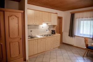 a kitchen with wooden cabinets and a sink and a window at Mösslhof App Laite in San Vito